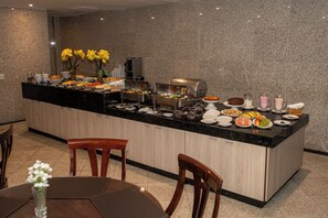 A modern kitchen with a central island, equipped with various appliances and food items. - Plaza Praia Suites (Fortaleza)