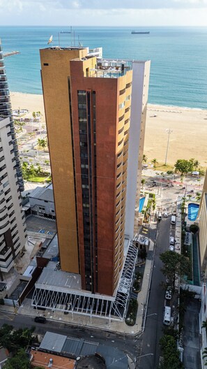 Un edificio alto con una torre centrale, vicino a una spiaggia e all'oceano.