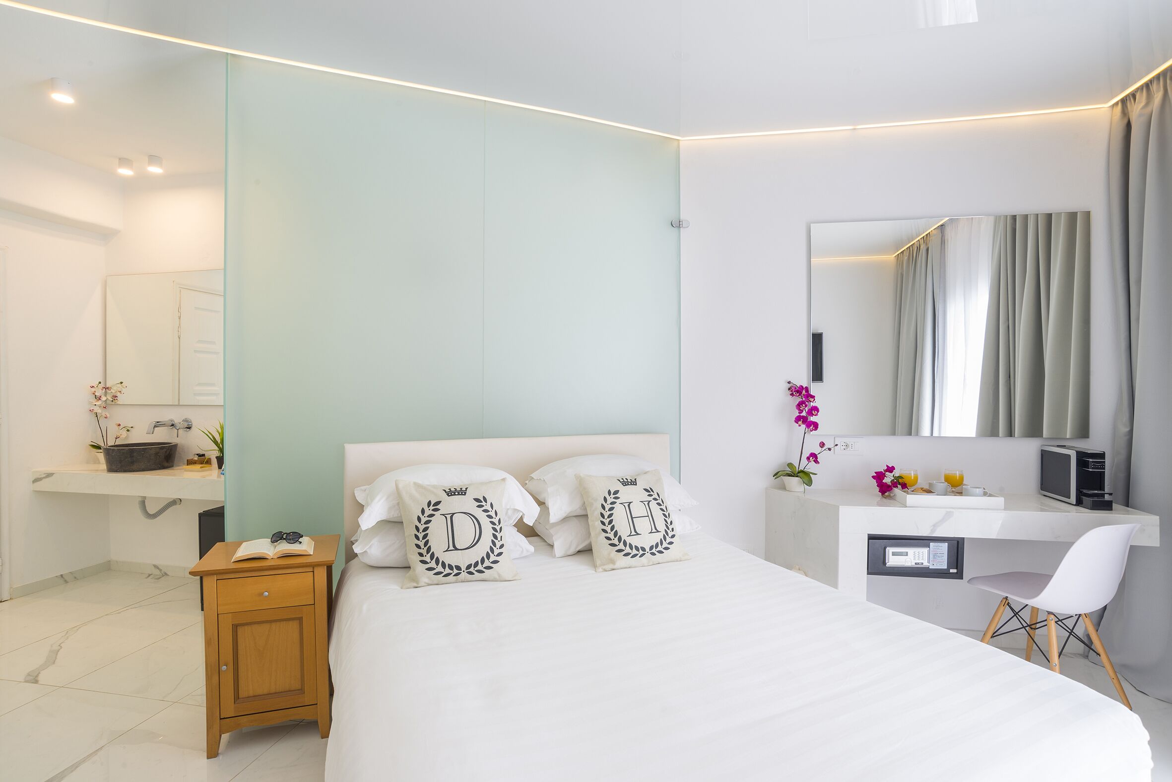Un dormitorio moderno con cama, mesita de noche y escritorio con silla.