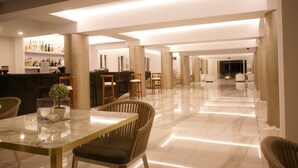A spacious lobby with a marble floor, a reception desk, and several seating areas.