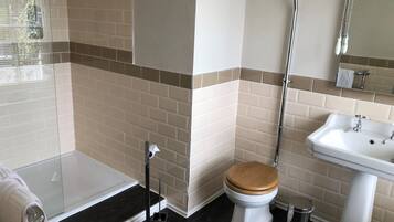 A bathroom with a toilet, sink, and shower.