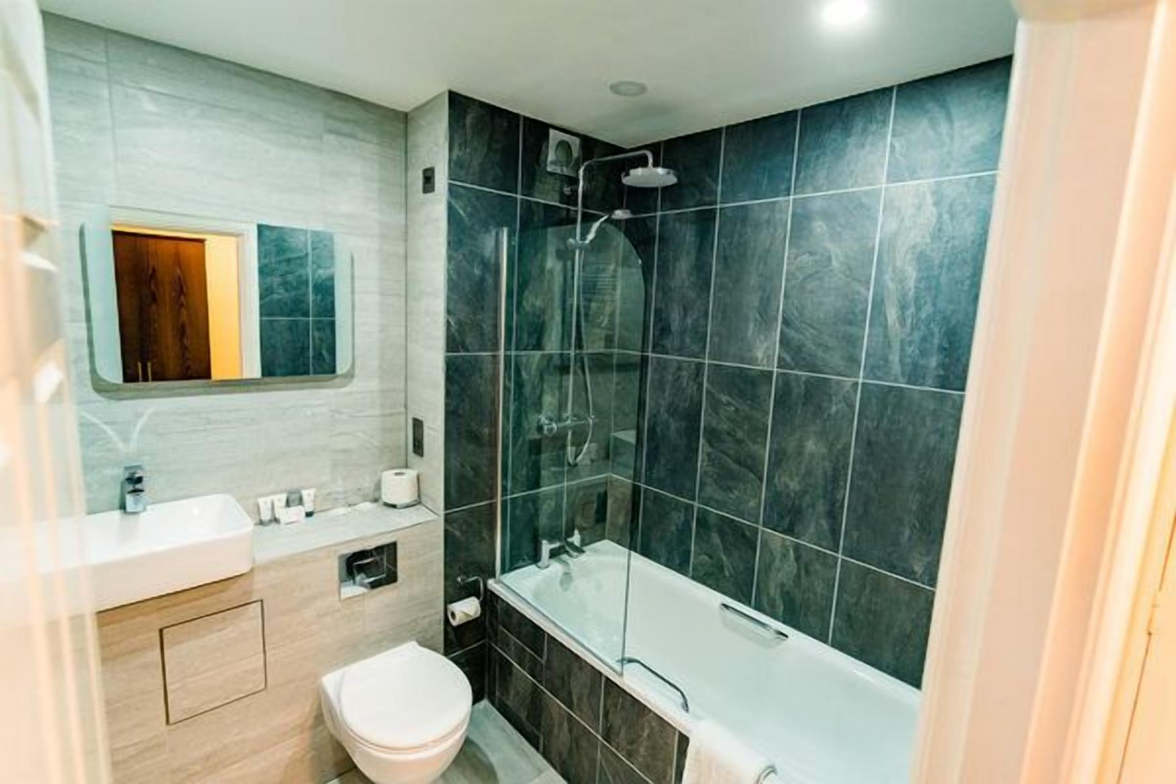 Un baño moderno con bañera, ducha e inodoro.