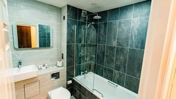 Un baño moderno con bañera, ducha e inodoro.