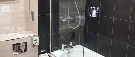 Ein modernes Badezimmer mit einer Duschkabine, einer weißen Badewanne und einem WC.