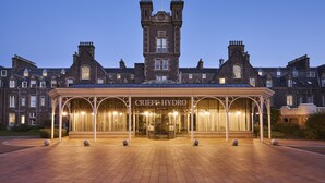 A grand hotel entrance with a prominent tower and a covered entrance area.