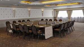 Une salle de conférence dotée d’une longue table, de chaises et d’un plafond pourvu d’un éclairage encastré.