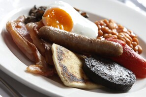 A plate of breakfast food including bacon, sausages, eggs, beans, tomatoes, and grilled mushrooms. - Best Western Queens Hotel (Perth)
