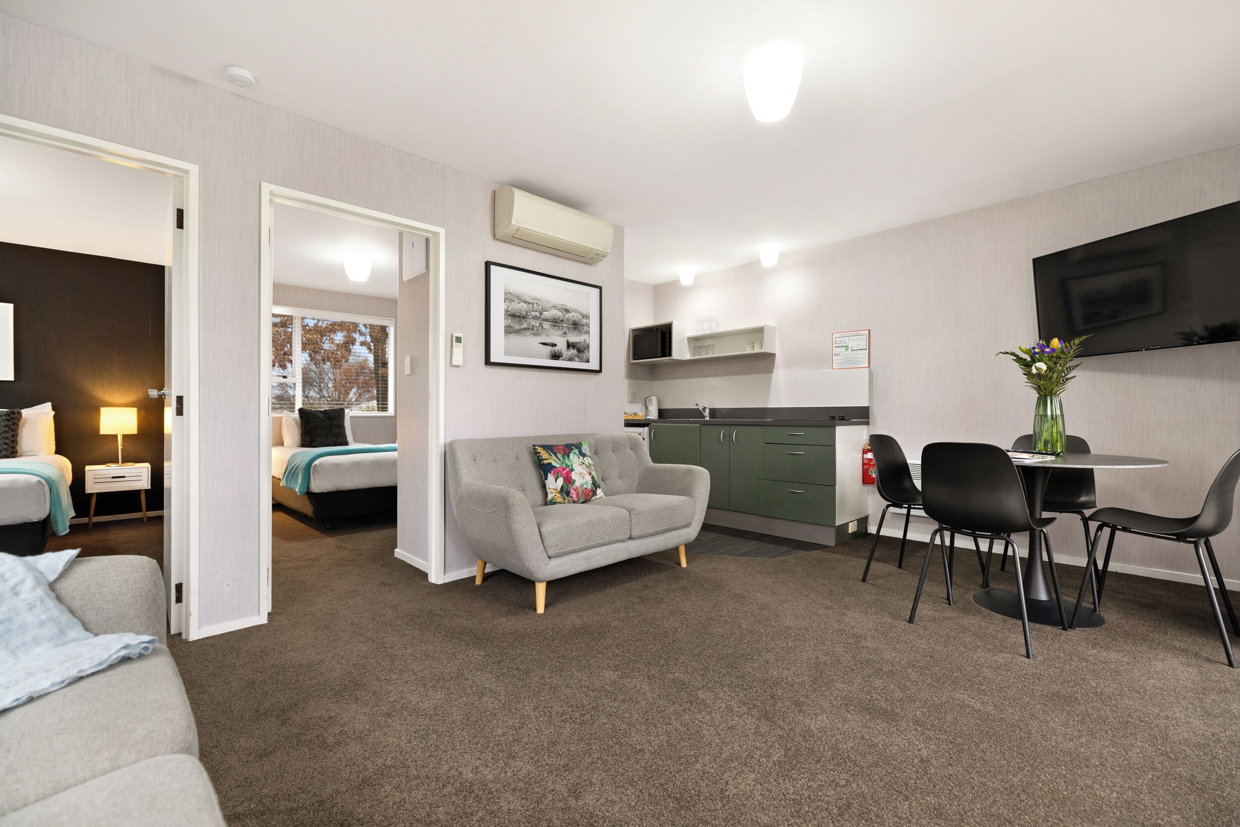 A compact living space with a kitchenette, a dining area, and a bedroom.