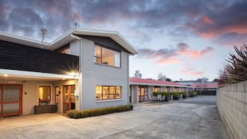 A modern building with a laundry facility, a covered outdoor seating area, and a well-lit entrance.