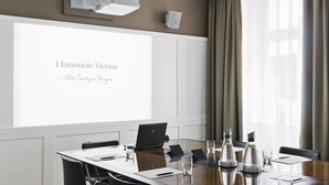 A conference room with a large projection screen displaying "Harmonie Vienna Art. Boutique. Unique." and a laptop on the table. - The Harmonie Vienna, BW Premier Collection (Vienna)