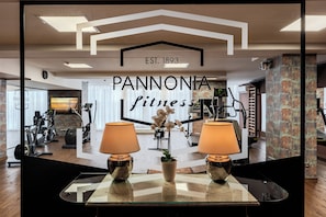 A gym interior with exercise equipment, a mirrored wall, and a sign reading 'PANNONIA fitness EST. 1893'. - Pannonia Hotel (Sopron)