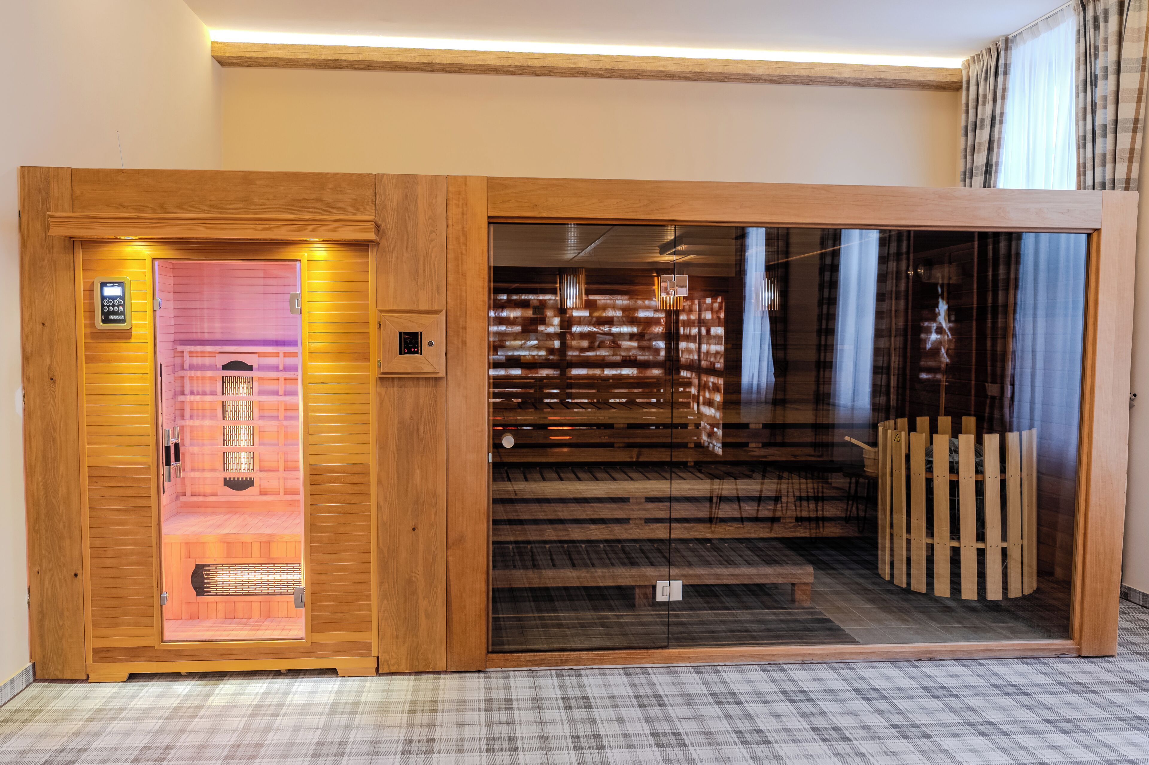 Een houten lift met een bedieningspaneel, leidend naar een ruimte met een geruite vloer en een glazen scheidingswand.
