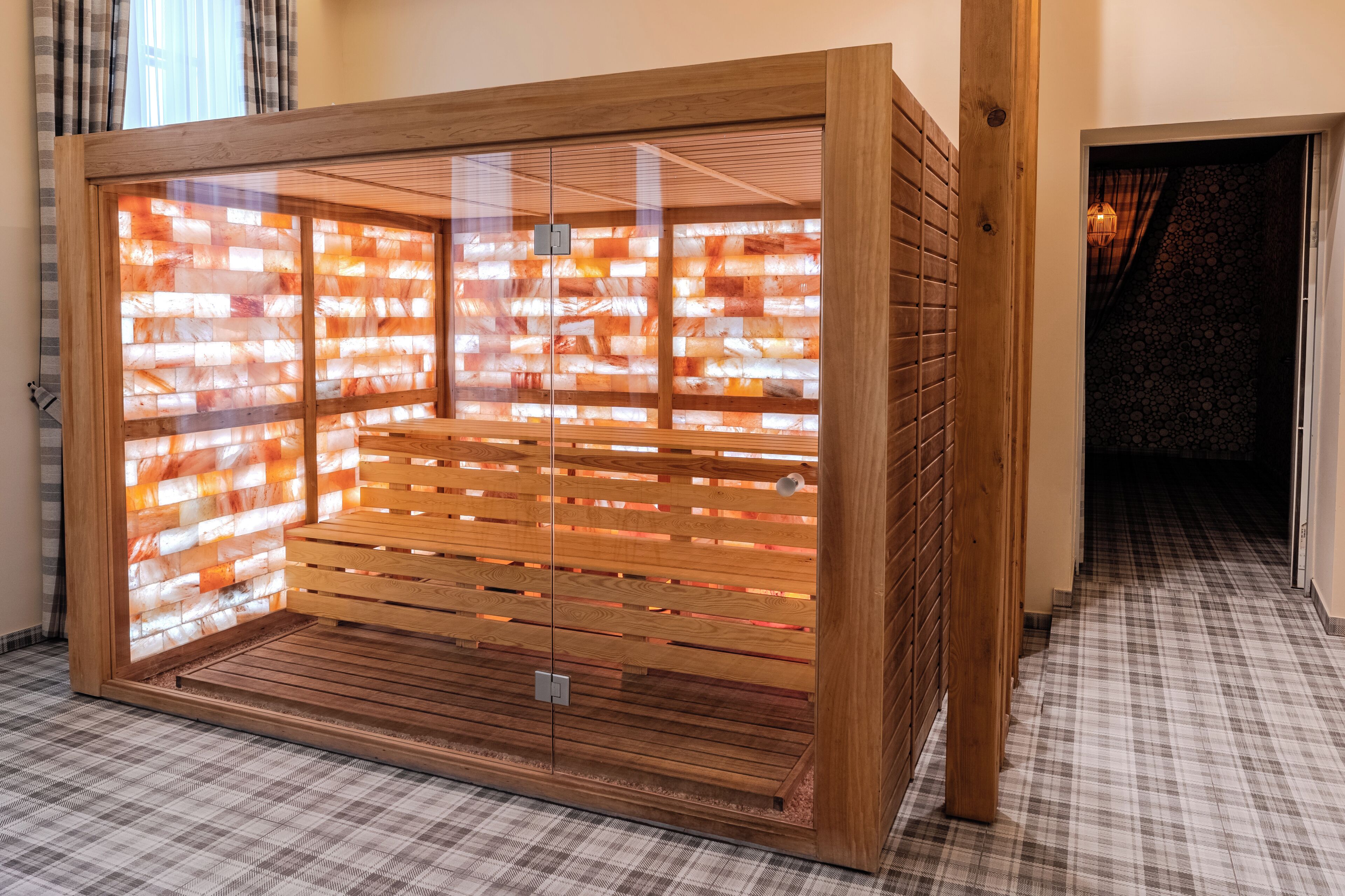 Uma sauna com bancos de madeira e estrutura de vidro.