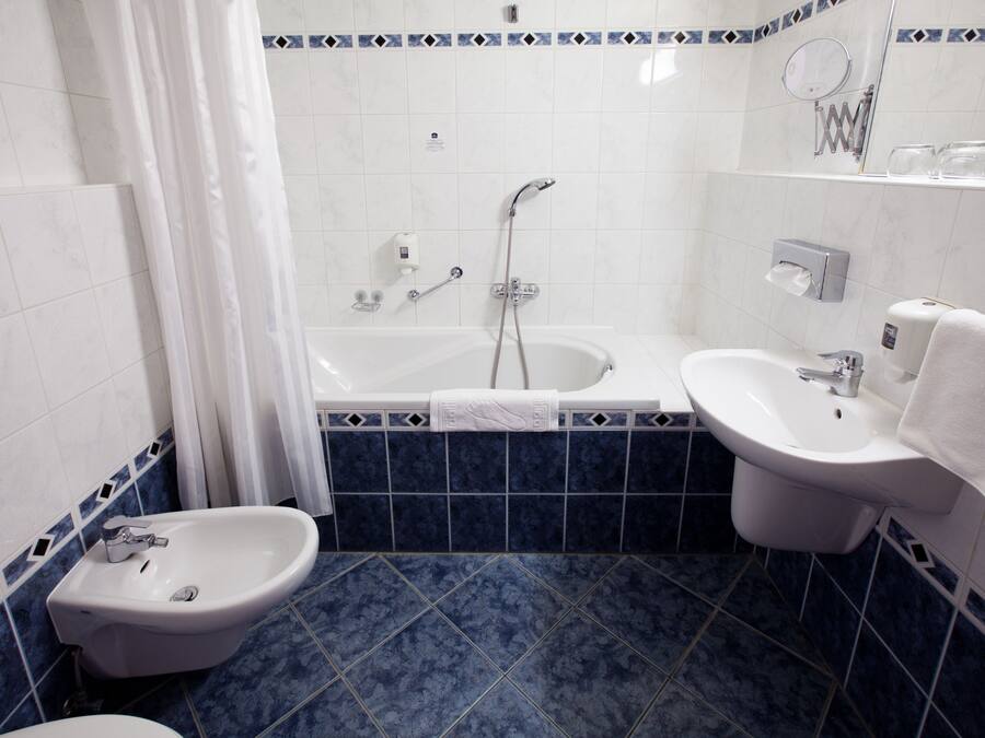 Une salle de bain équipée d’une baignoire, de deux lavabos, d’un bidet et de toilettes.