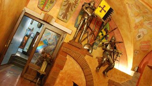 A church interior with a wooden altar, stained glass windows, and medieval armor displays. - Pytloun Old Armoury Hotel Prague (Prague)