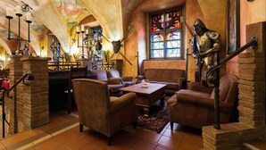 A cozy interior with leather sofas, a wooden coffee table, and a stained glass window. - Pytloun Old Armoury Hotel Prague (Prague)
