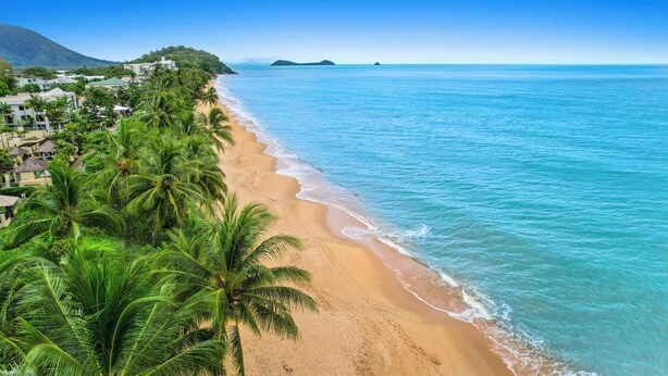 A beach with clear turquoise waters, palm trees, and a mountainous backdrop. - Trinity Beach Pacific (Trinity Beach)