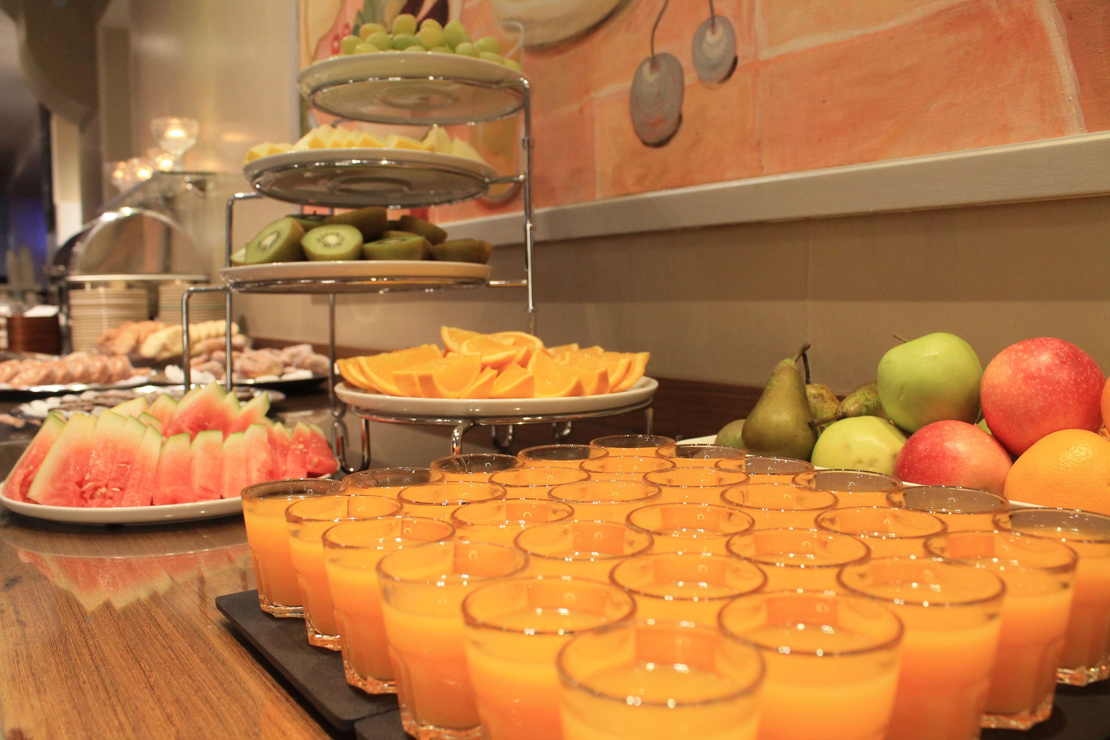 Een buffet met diverse soorten fruit en vruchtensappen.