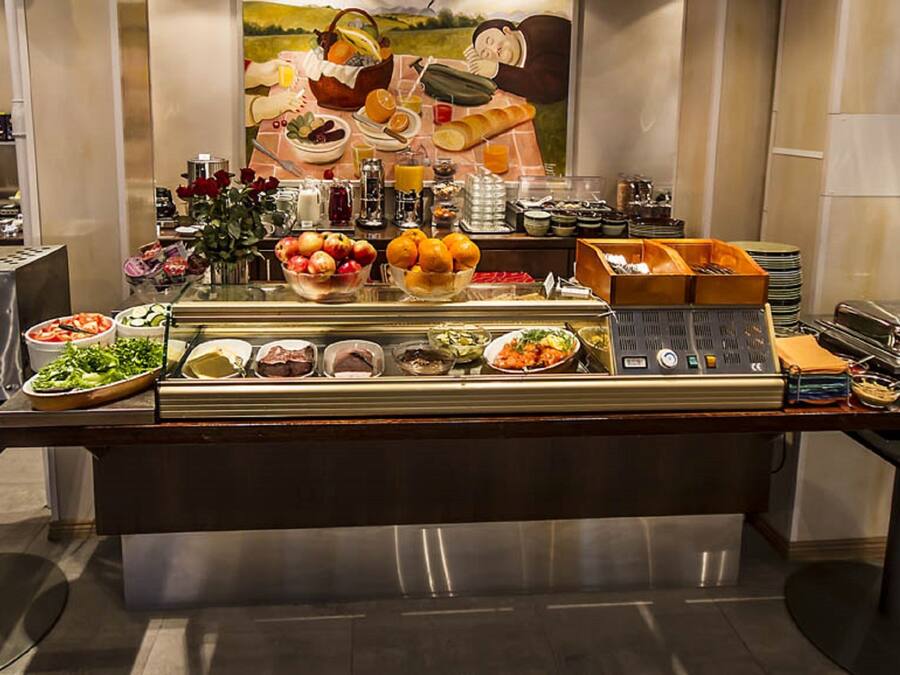 Una mesa de buffet con diferentes platos y un cuadro al fondo.