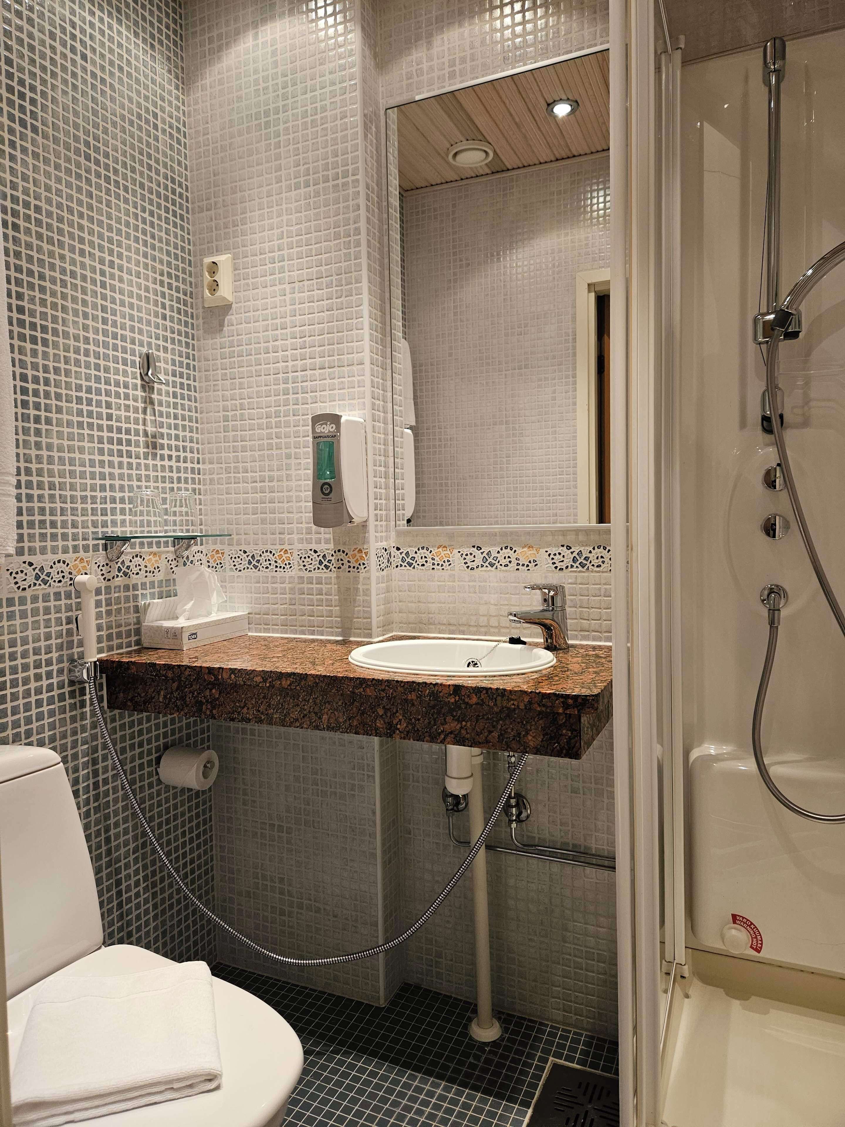 Un baño con lavamanos, inodoro y ducha.