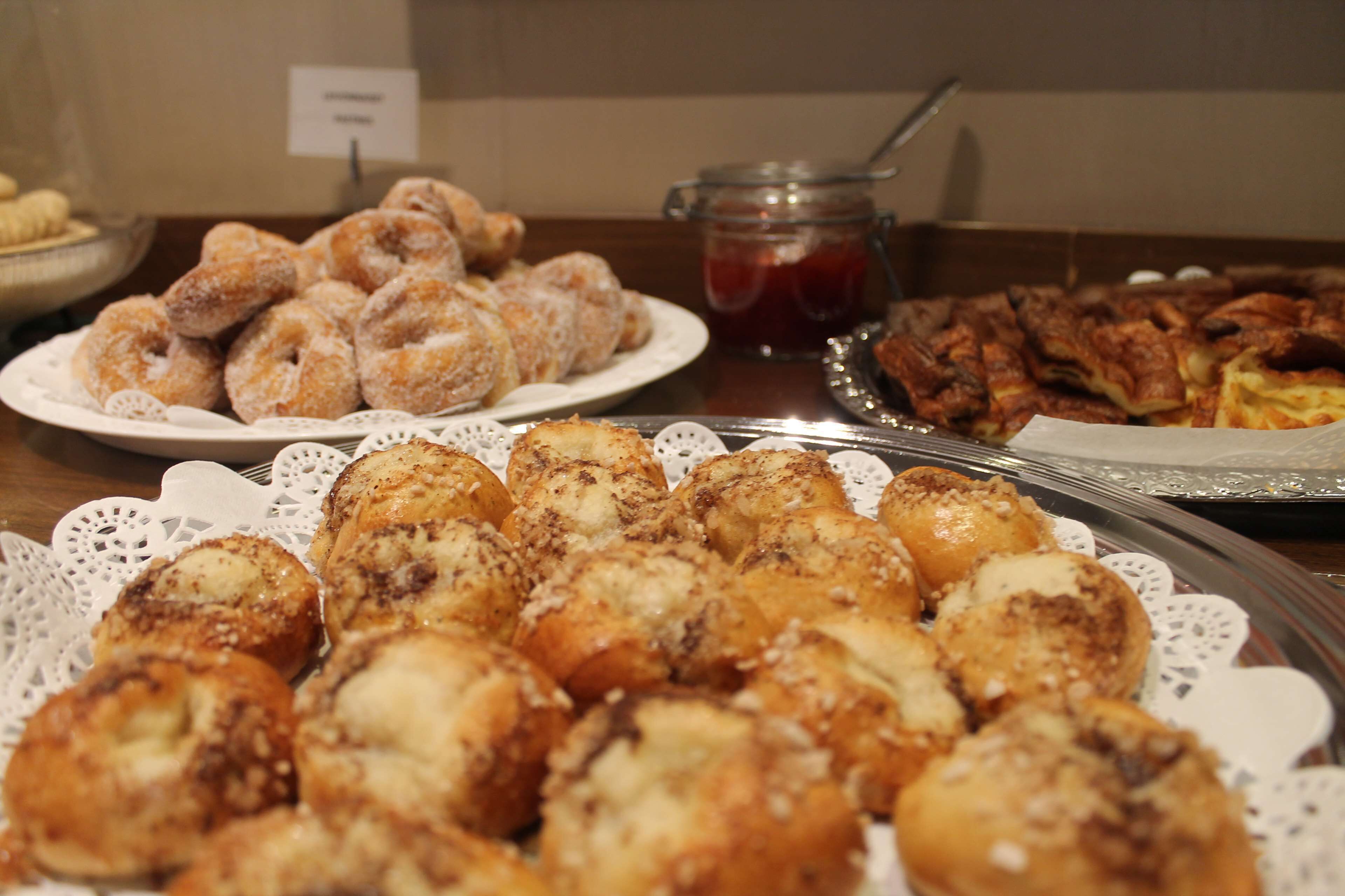 Une table avec divers pâtisseries et un pot de confiture.