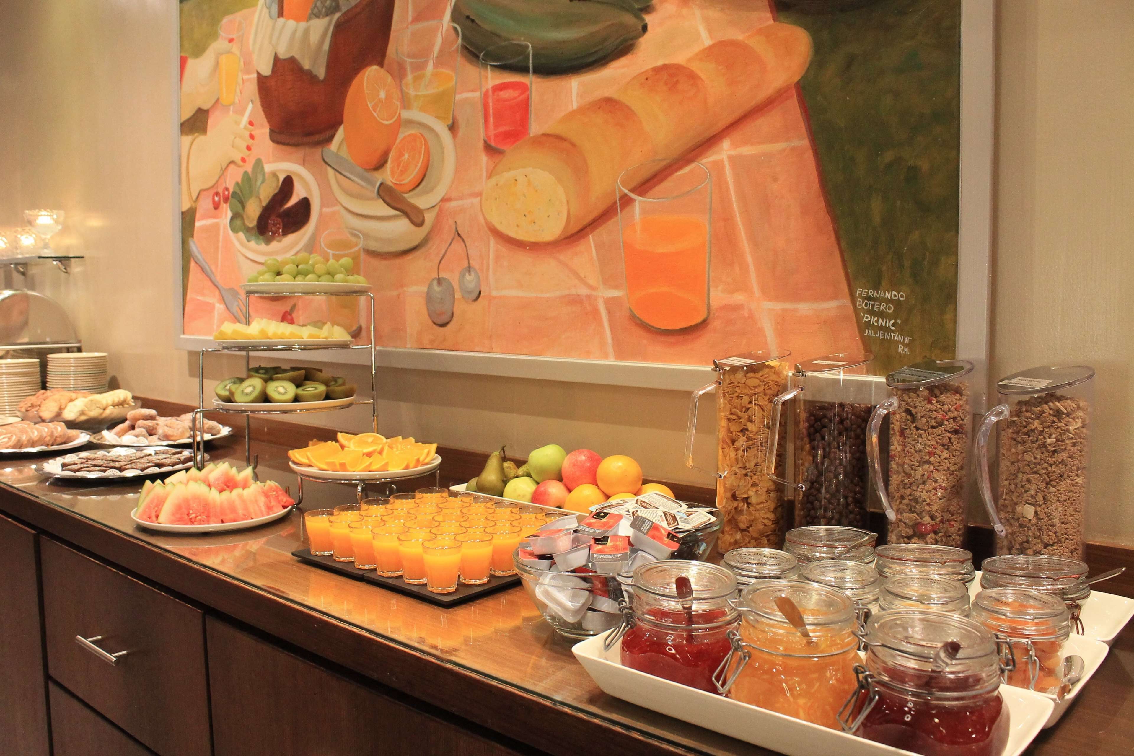 Un buffet proposant une variété de plats et de boissons, notamment des fruits, des pâtisseries et des jus de fruits.