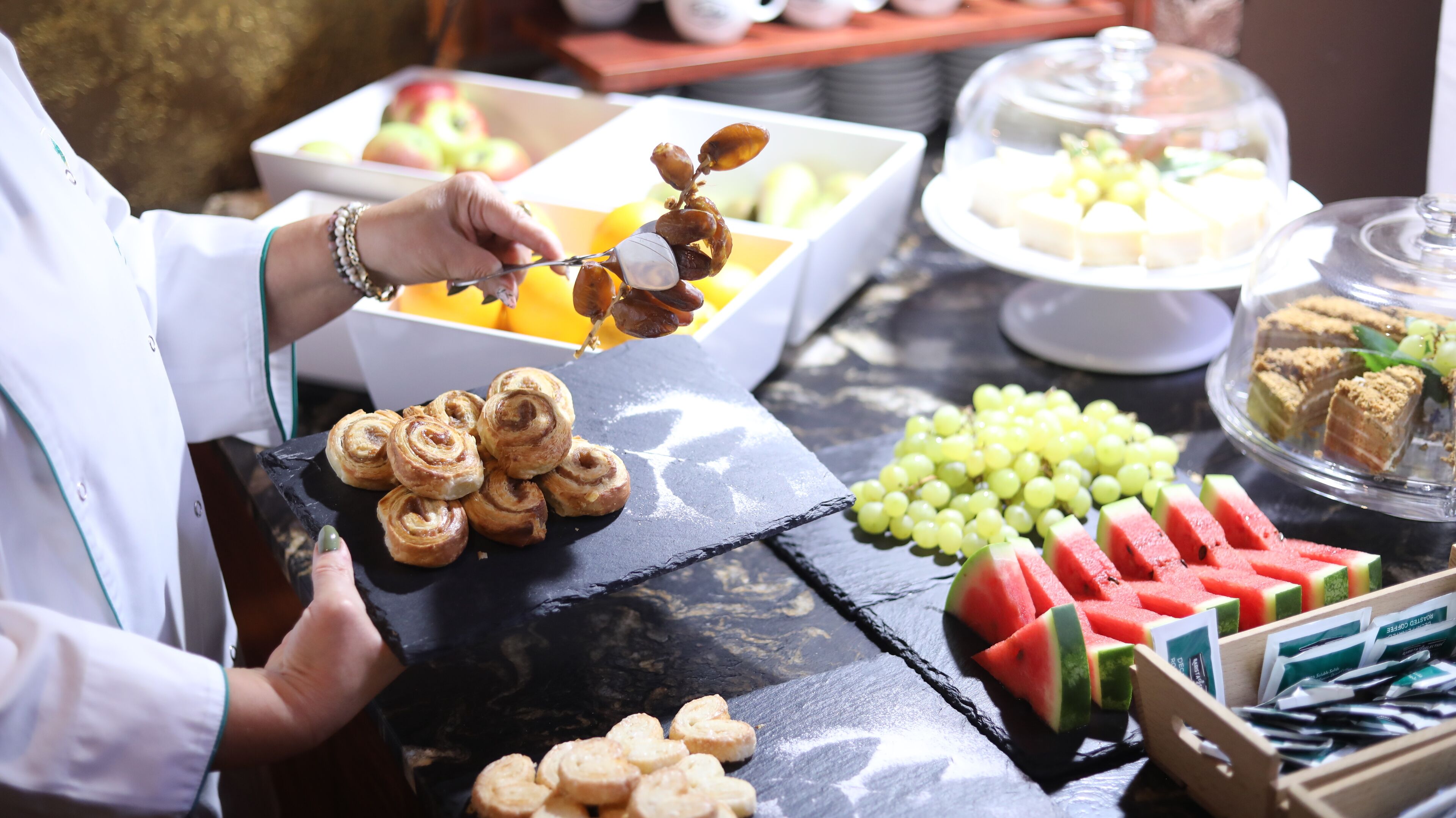 Een buffettafel met gebak, fruit en desserts.