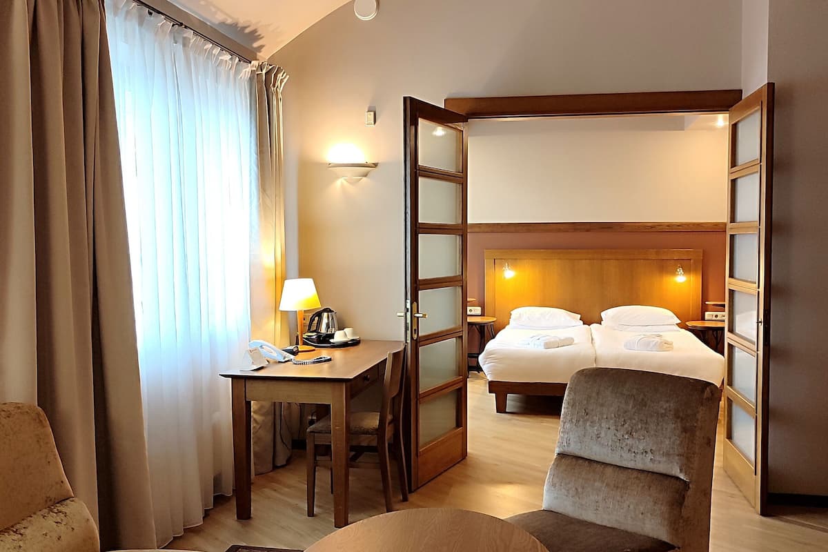 suite, multiple beds, smoking (living room) | living area | tv, heated floors