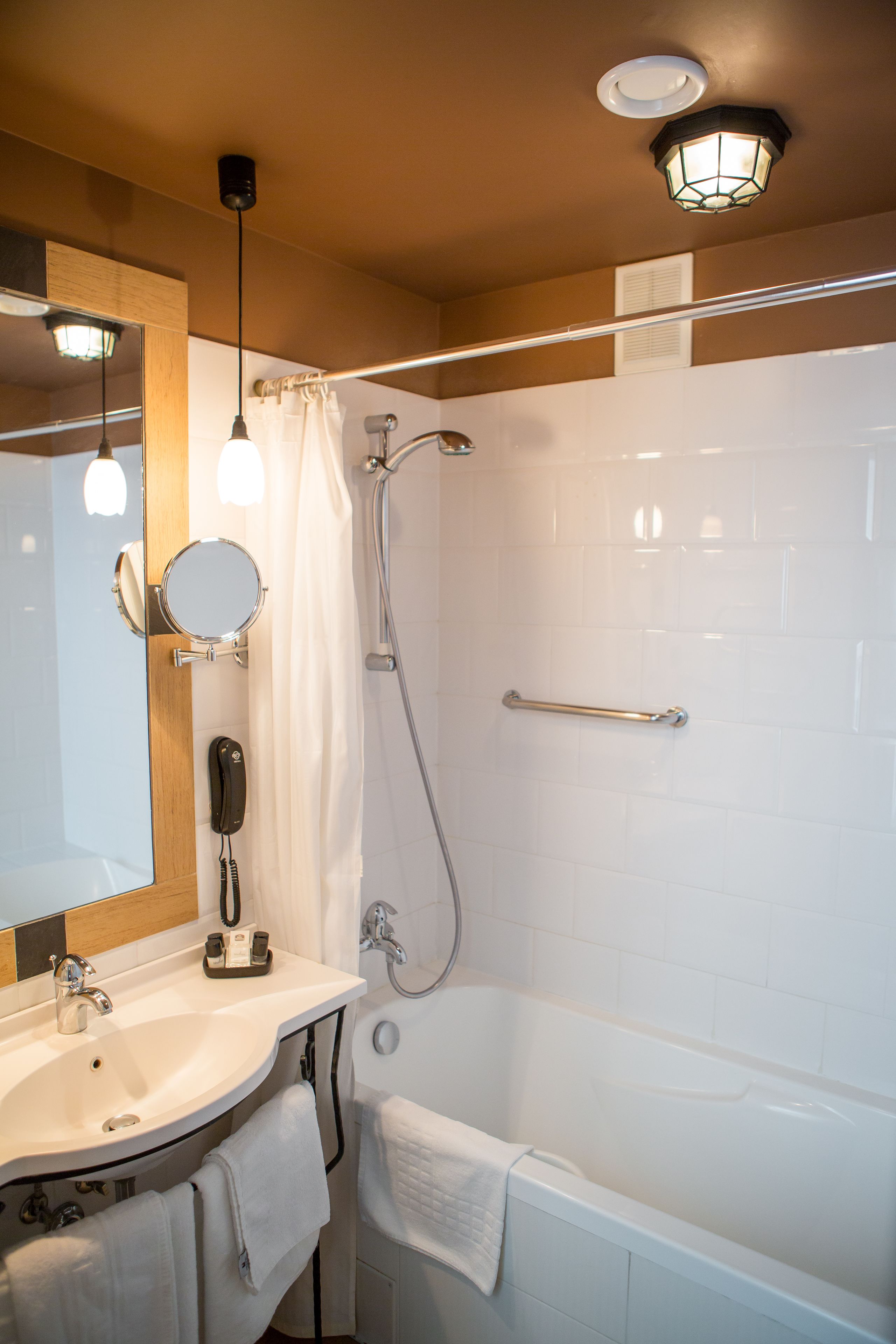 A bathroom with a sink, mirror, and shower.