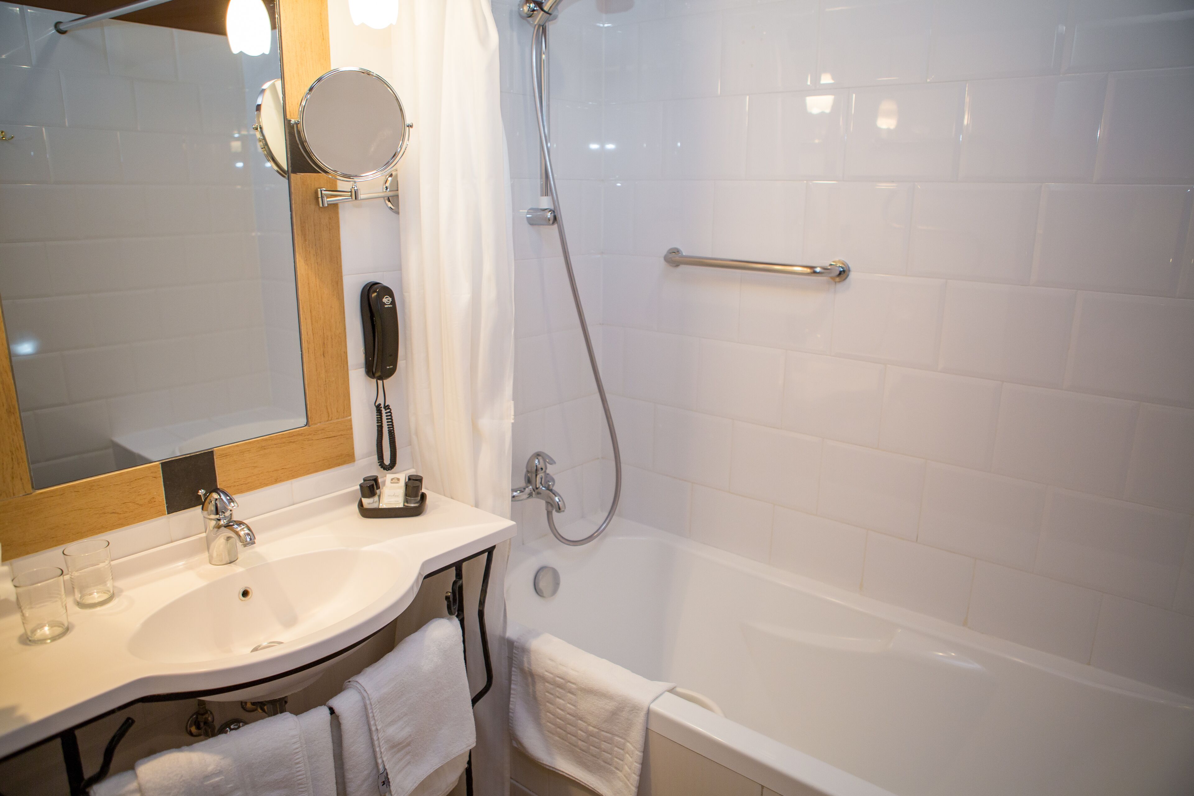 A bathroom with a sink, mirror, and shower.