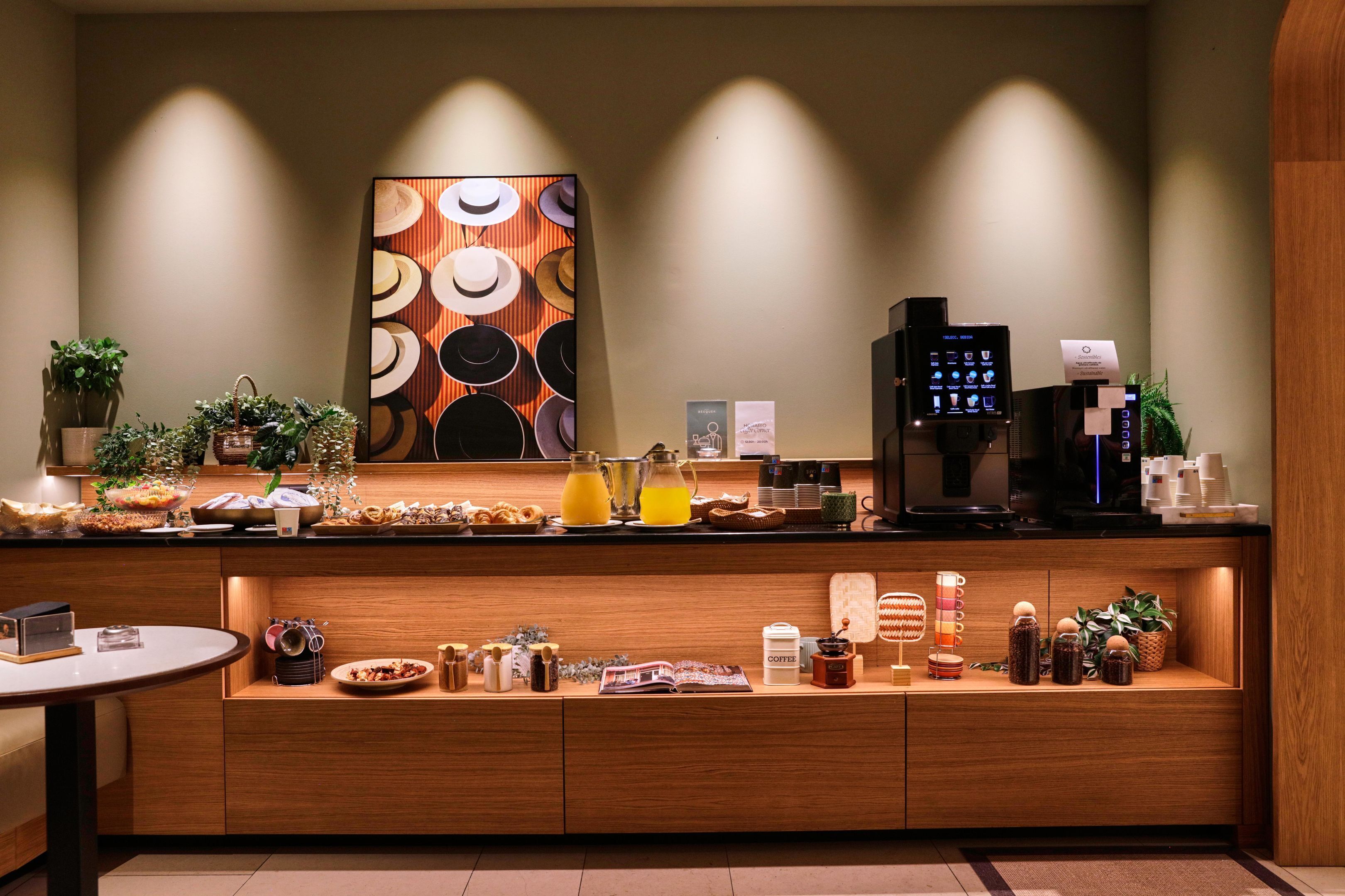Un espace cuisine moderne comprenant une machine à café, un panier de fruits et divers condiments.