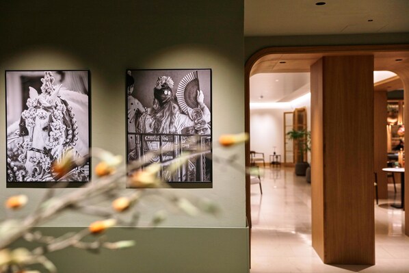 Two black and white photographs on a wall, a wooden column, and a glimpse of a dining area. - Becquer Hotel, Historic City Center (Seville)