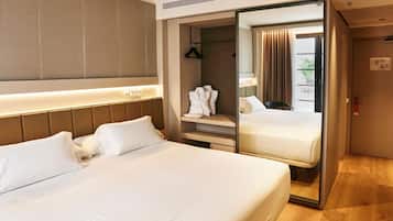 Ein Hotelzimmer mit einem großen Bett, einem begehbaren Kleiderschrank und einem Spiegel.