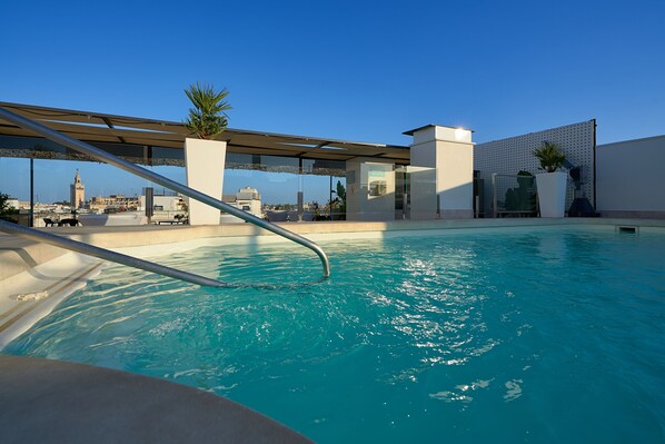 Piscine extérieure en saison, parasols, chaises longues