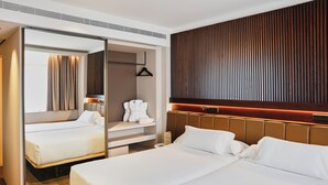 A modern hotel room with a large bed, a walk-in closet, and a wooden panel wall. - Becquer Hotel, Historic City Center (Seville)