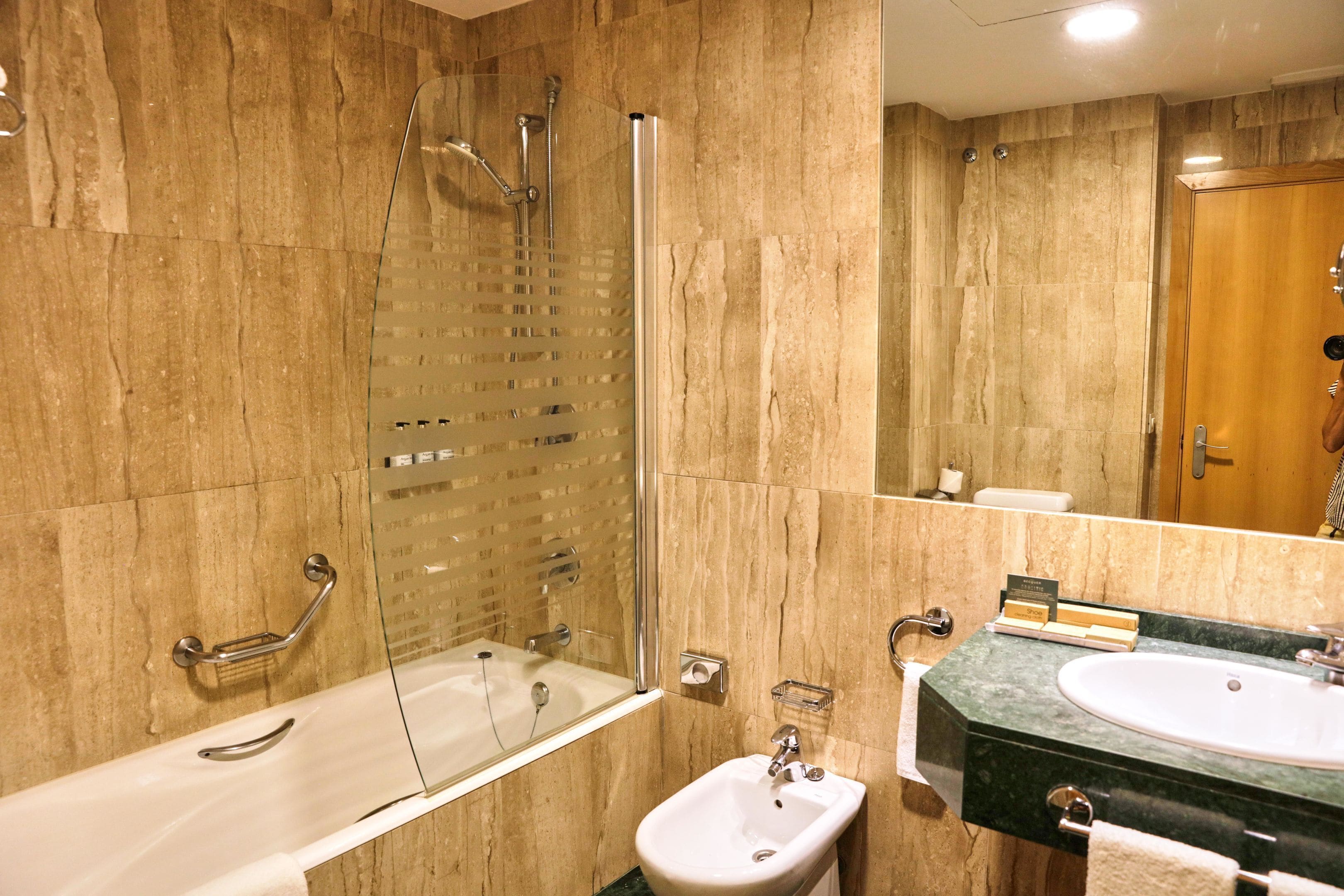 Une salle de bain avec une baignoire, une douche, un lavabo et un miroir.