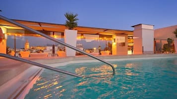 Una piscina al aire libre de temporada, sombrillas, tumbonas