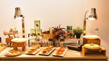 A buffet with various food items, including sandwiches, salads, and a cake, arranged on wooden stands with labels.