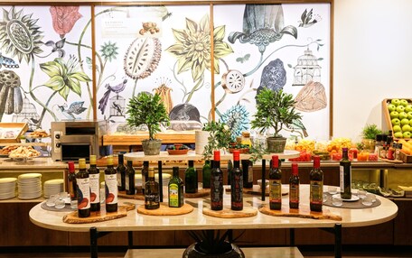 A buffet table with various food items and bottles of wine.