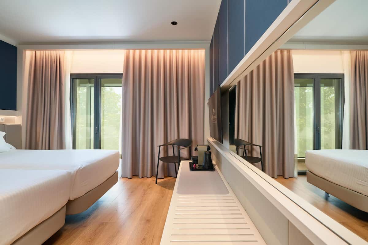 Deluxe Room, Balcony | Minibar, in-room safe, soundproofing, iron/ironing board