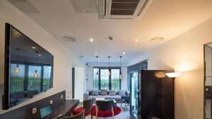 Una sala moderna con comedor, ventanas amplias y chimenea.