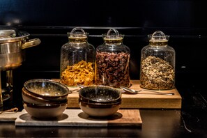 A kitchen counter with three glass jars containing different food items, a metal pot, and two ceramic bowls. - Hotel Ambassador Bosten (Eupen)