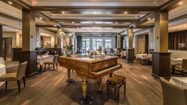 Un hall d’hôtel spacieux, doté d’un magnifique piano à queue, de sièges confortables et d’un design moderne.