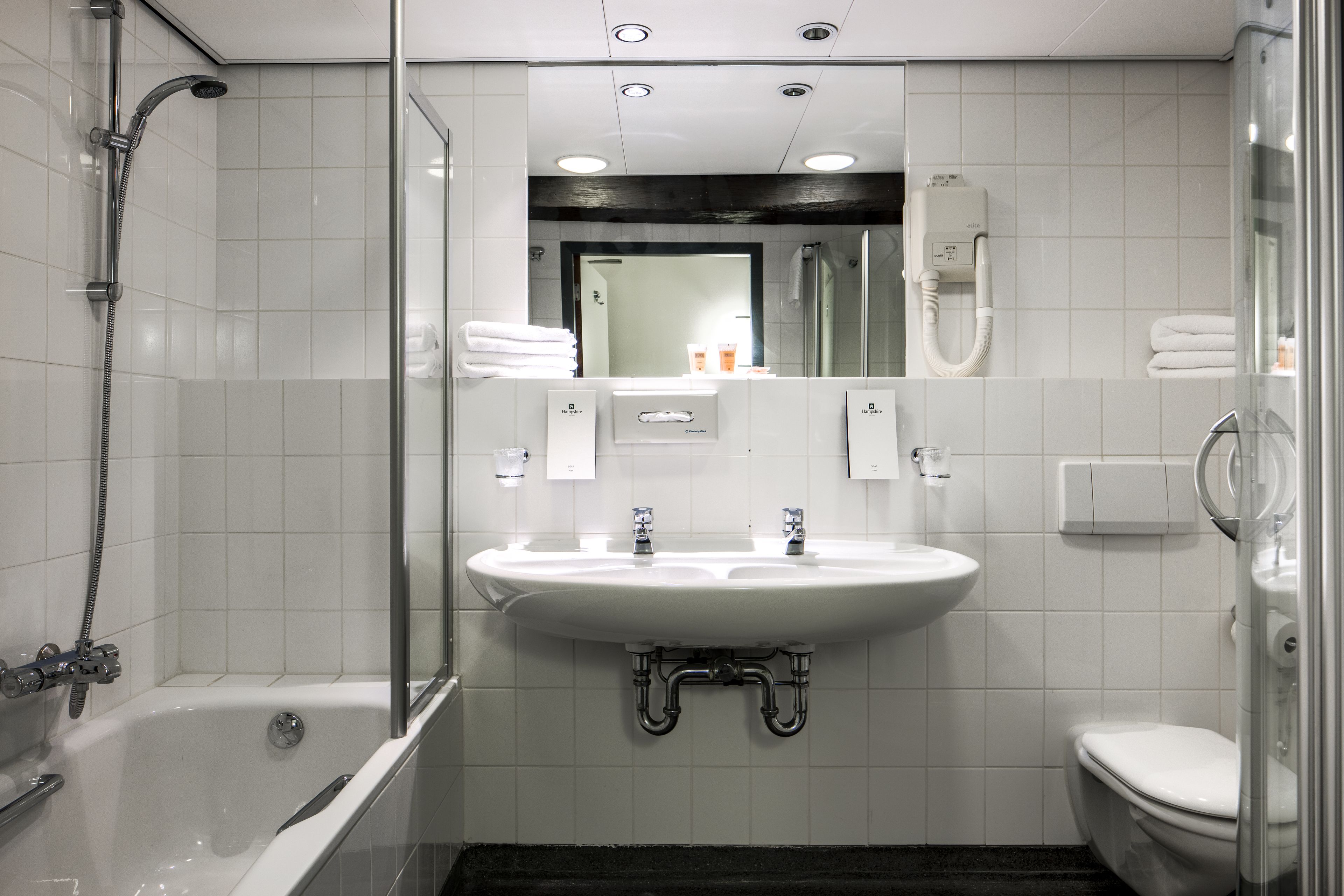 A modern bathroom with a bathtub, a sink, and a toilet.