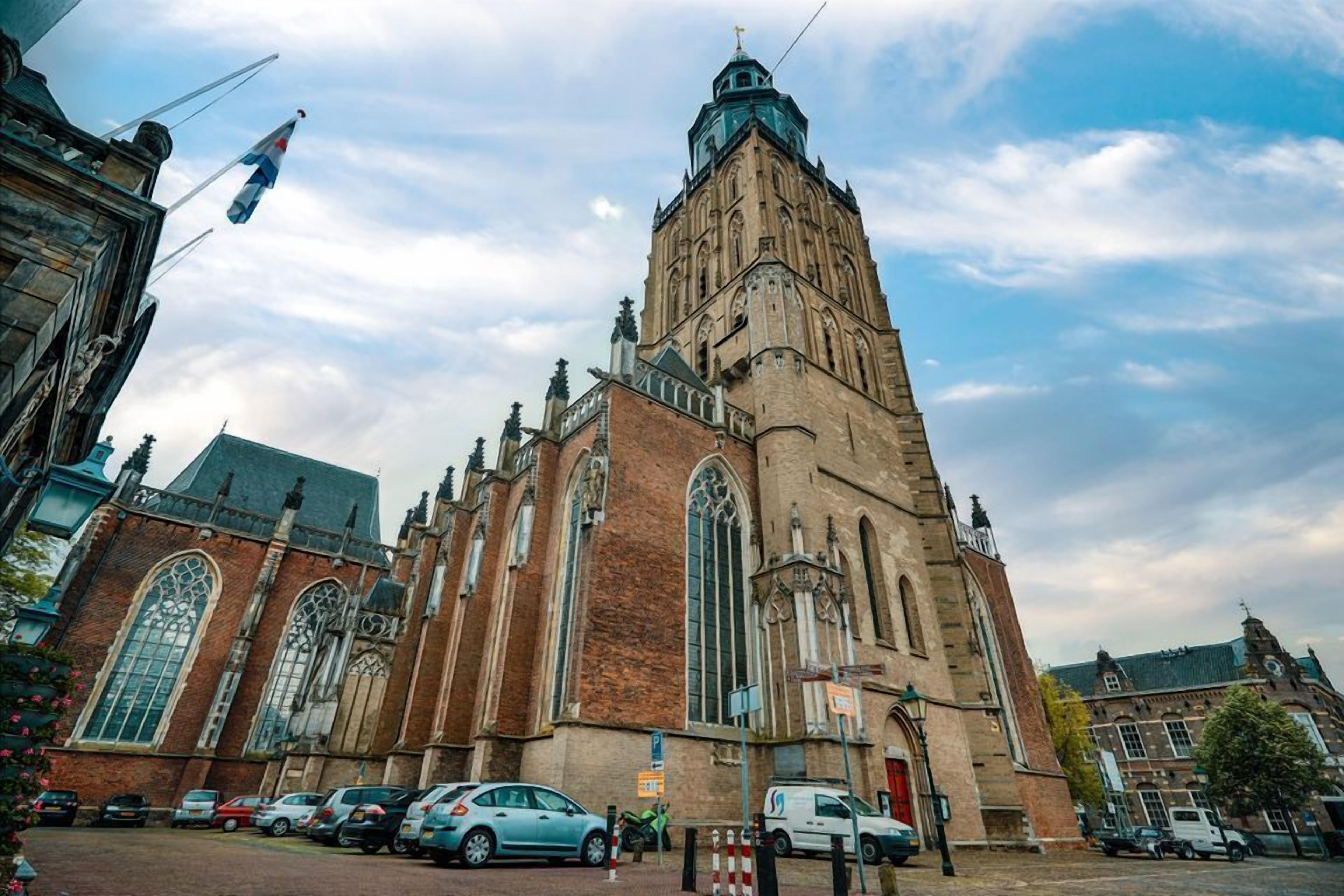 Una iglesia histórica con una torre alta y amplias ventanas de arco.