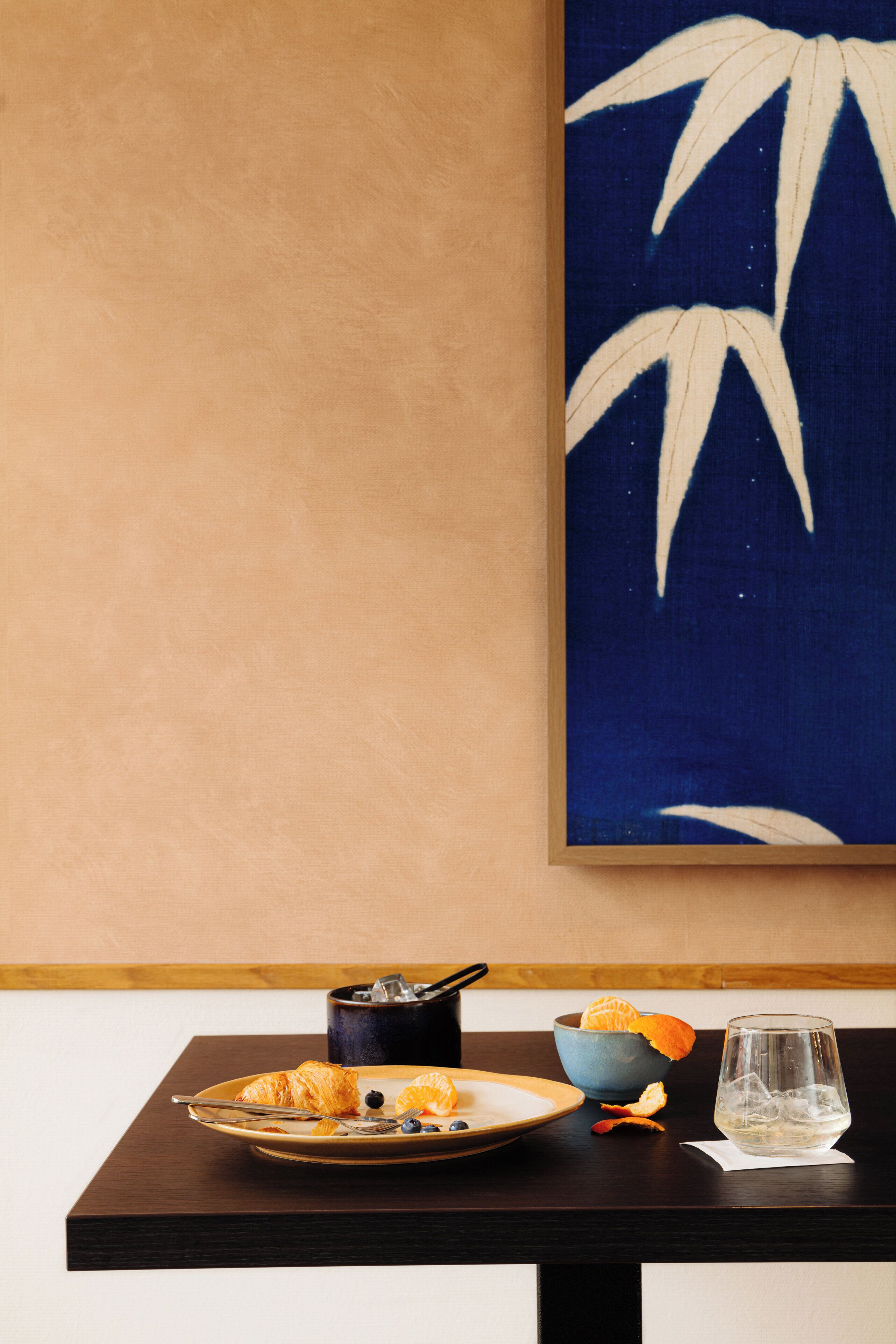 Une table à manger avec une assiette de nourriture, un bol et un verre.