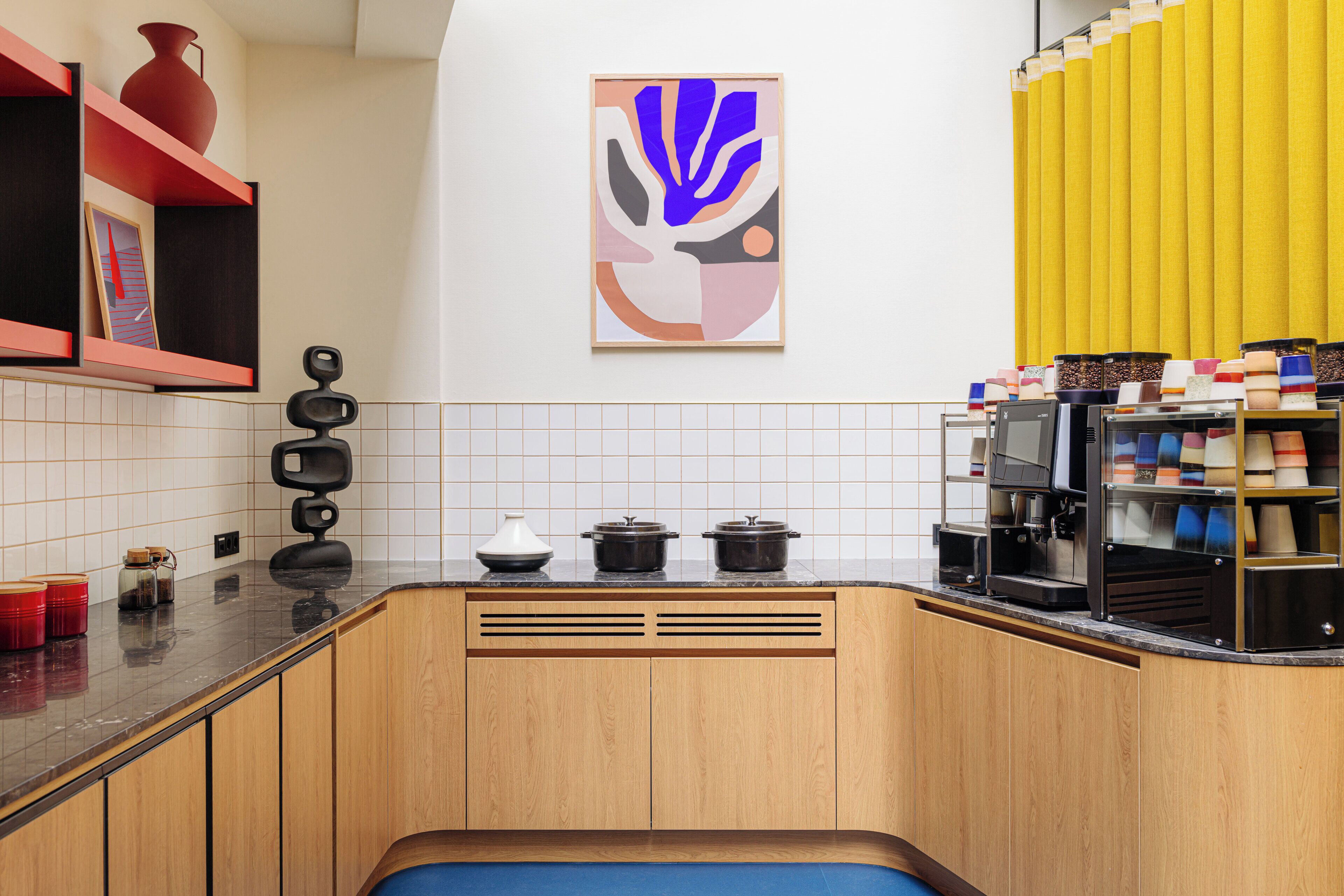 A modern kitchen with wooden cabinets, a coffee machine, and a yellow curtain.