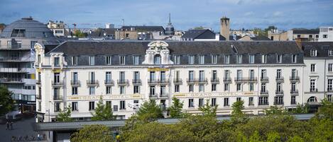 A historic hotel with a classic European architectural style, featuring a symmetrical facade, multiple balconies, and a prominent central entrance.