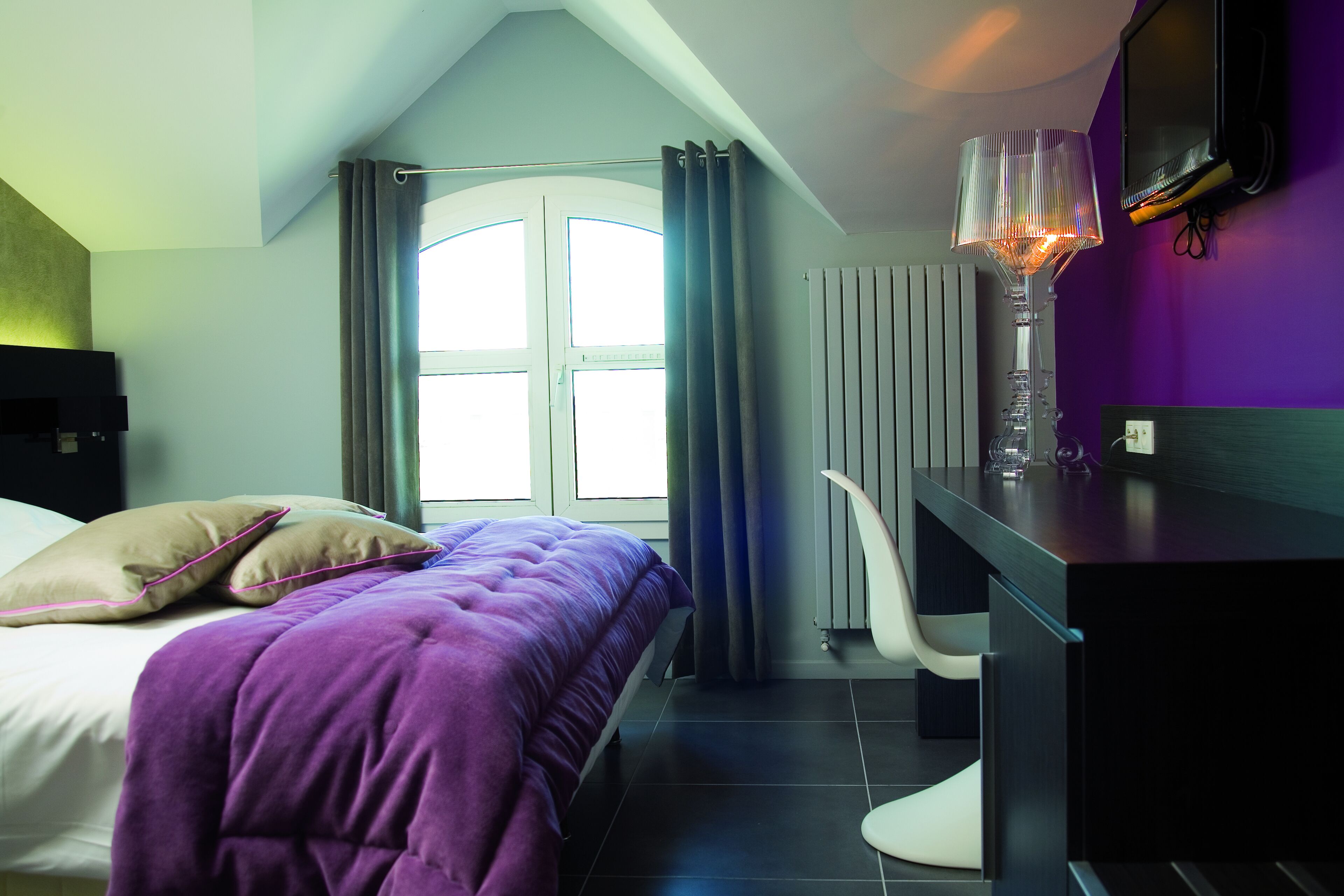 Un dormitorio moderno con una cama, un escritorio y una silla.