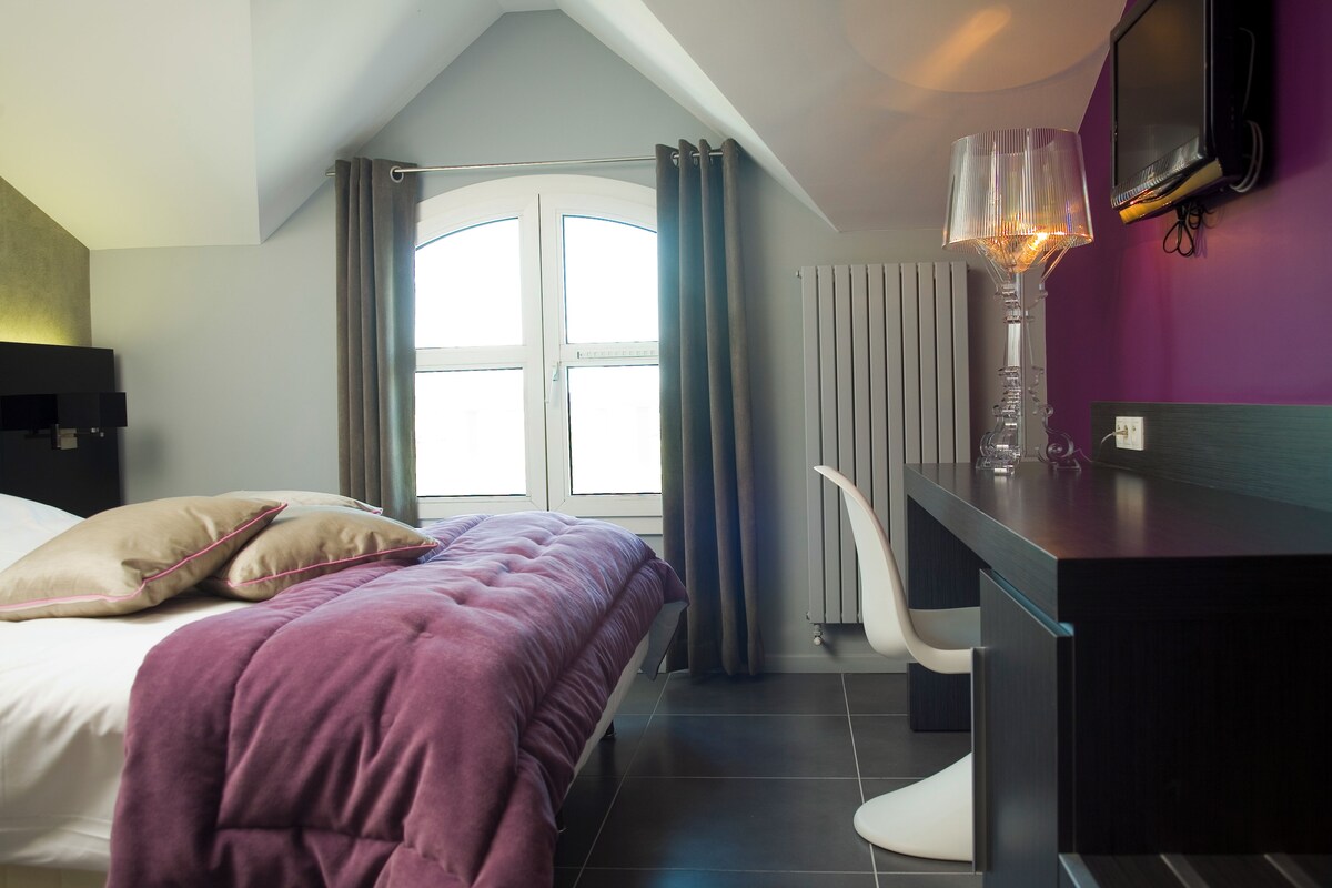 Un dormitorio moderno con cama, escritorio y silla.